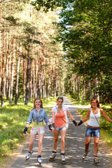 Three friends roller skating outdoor hold hands