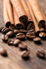 Coffee and cinnamon sticks on wooden background close up vertica