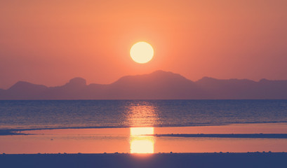 Vintage sunset over tropical sea and island,filtered image