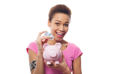 Fototapeta na wymiar Woman putting money in piggy bank