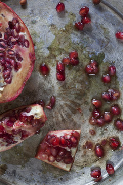 red and juicy pomegranate and grains on ancient silver tray