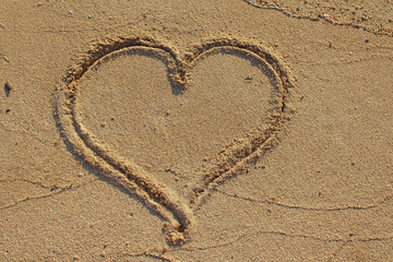 Heart shape drawn on beach sand