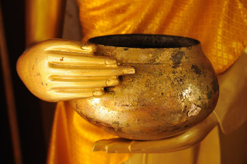 Close up hand of  statue Buddha holding monk  alms-bowl