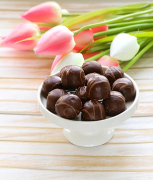 Chocolate Candy And Flowers On White Background