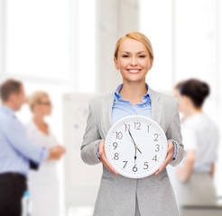 smiling businesswoman with wall clock