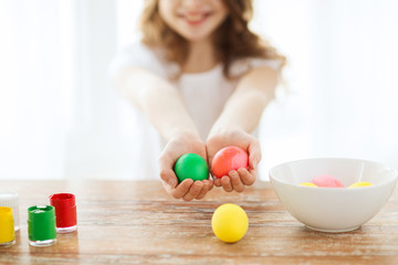 close up of girl holding colored eggs