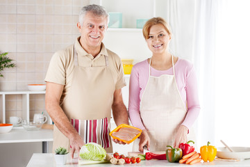 Obraz na płótnie Canvas Happy Senior Couple preparing food in the kitchen.