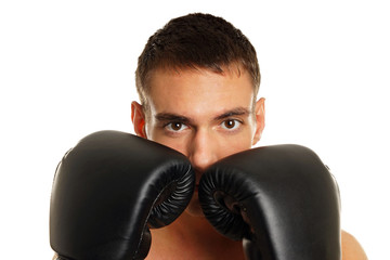 Young man with boxer gloves at his face