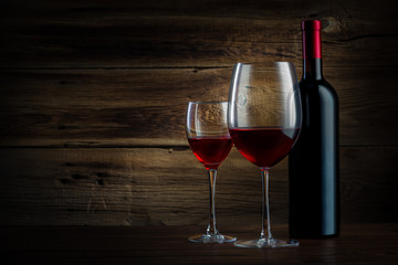 glass and bottle of wine on a wooden background