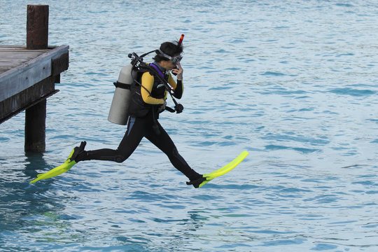 Scuba Diver Performing a Giant Stride Entry From a Dock - Bonair