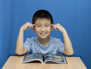 Asian Boy success to read a book on blue background