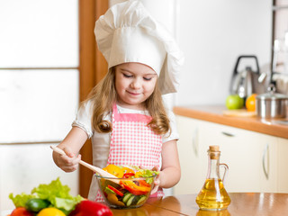 kid making salad at kitchen