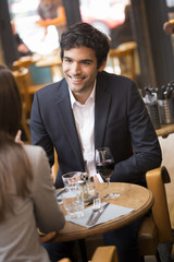 Cheerful couple drinking red wine in French restaurant