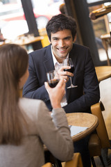 Cheerful couple drinking red wine in French restaurant