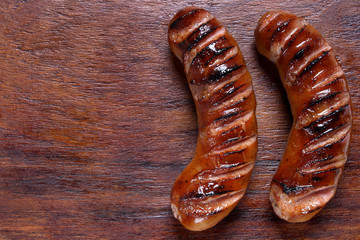 Grilled sausages on wooden board
