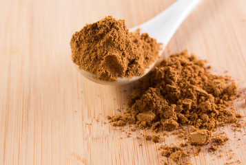 spoon with guarana on a wooded plate