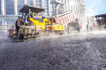Fototapeta premium Workers making asphalt with shovels at road constructio