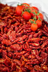 Heap of sundried tomatoes with fresh tomatoes on the vine