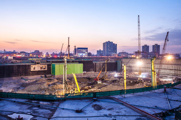 Construction site with cranes and illumination at night