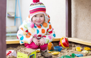Fototapeta na wymiar cute little girl in a sandbox