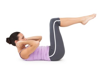Fototapeta na wymiar Side view of a fit young woman doing crunches