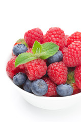 close-up of bowl with fresh juicy berries and mint, isolated