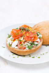 sandwich with cheese, tomato and salmon on the plate, vertical