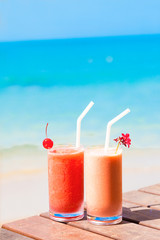 picture of two cocktails on a table near beach