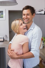Happy young couple embracing in the kitchen