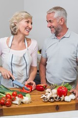 Mature couple preparing food together in kitchen