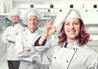 team chef man woman modern kitchen. smiling positive uniform