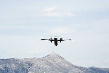 Fototapeta na wymiar small plane taking off or landing with mountain background