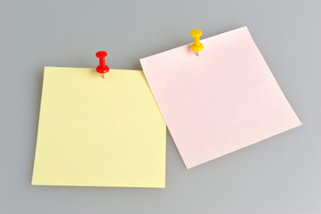Two paper sheets attached with office buttons on gray background