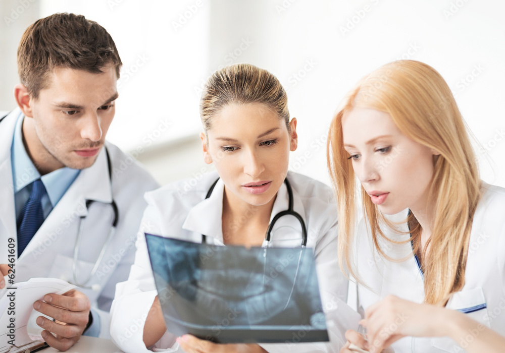 Poster young group of doctors looking at x-ray