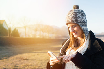 Young student woman using smartphone outdoors