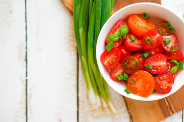 Colorful tomatoes on board on wooden background