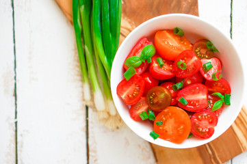 Colorful tomatoes on board on wooden background