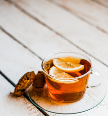 Tea cup with lemon and cookies on rustic wooden background