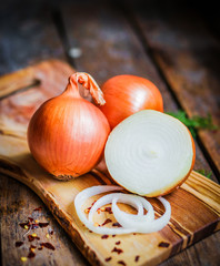 Golden onions on rustic wooden background