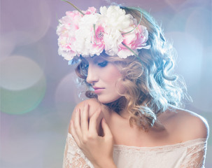 Portrait of a beautiful blonde woman with flowers in her hair.