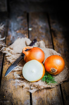 Golden onions on rustic wooden background