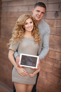 Pregnant woman and husband hold ultrasound scan baby
