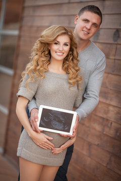 Pregnant woman and husband hold ultrasound scan baby