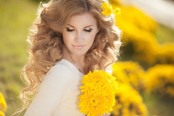 Naklejka premium Beautiful woman with spring flowers outdoor