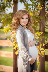 Beautiful pregnant woman with spring flowers outdoor