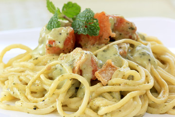 Spaghetti and salmon in pesto sauce