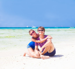 happy young couple in bright clothes in sunglasses