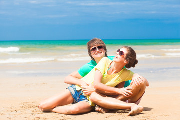 happy young couple in bright clothes in sunglasses