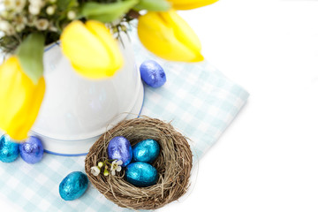Easter setting with yellow tulips and chocolate eggs
