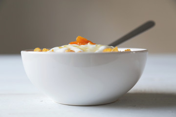 Cornflakes in einer Schale mit Joghurt und Honig.